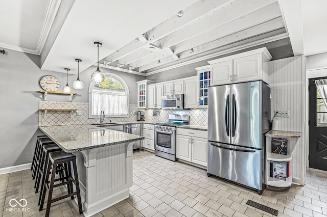 kitchen featuring a peninsula, a sink, visible vents, appliances with stainless steel finishes, and glass insert cabinets