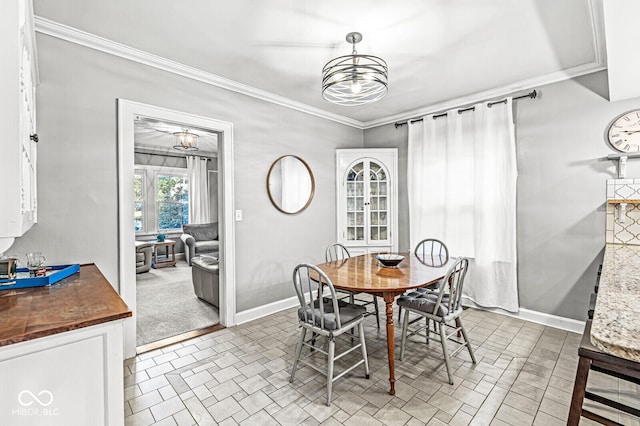 dining area with a notable chandelier, ornamental molding, and baseboards