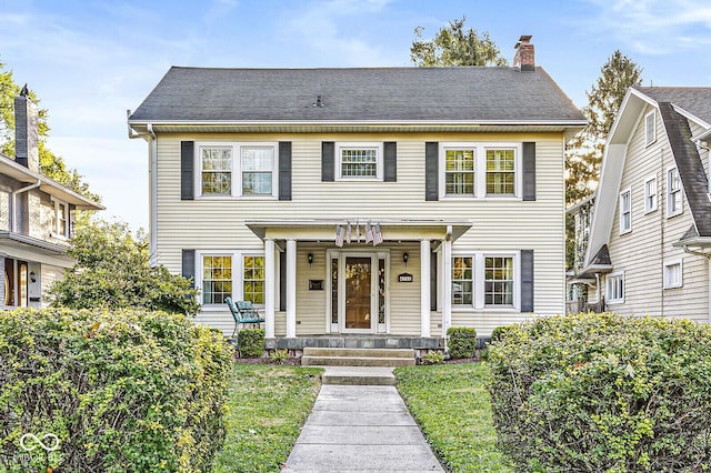 view of front of home featuring a shingled roof and a chimney