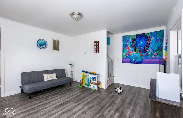 living area with baseboards, visible vents, and wood finished floors