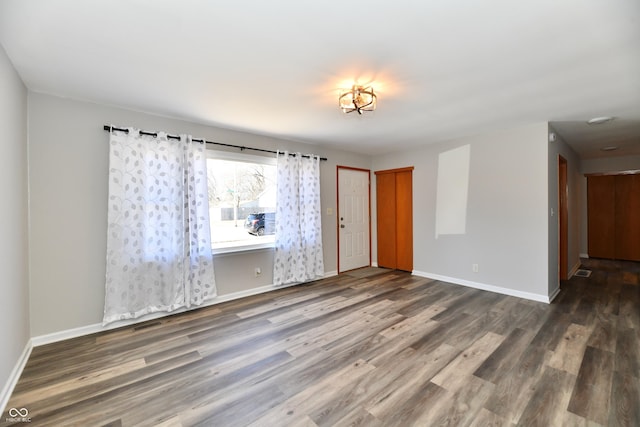 spare room featuring baseboards and wood finished floors