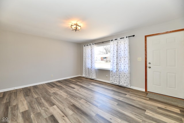 empty room with baseboards and wood finished floors