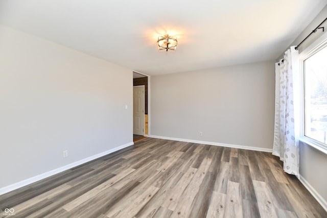 spare room with wood finished floors and baseboards