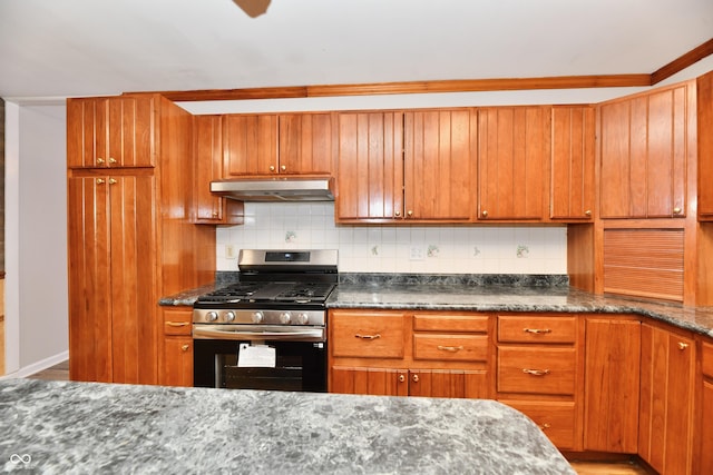 kitchen with stainless steel gas stove, under cabinet range hood, brown cabinets, and decorative backsplash