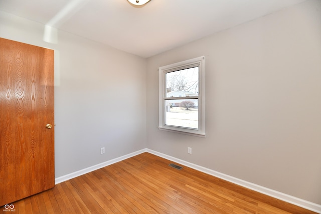 unfurnished room with light wood finished floors, baseboards, and visible vents