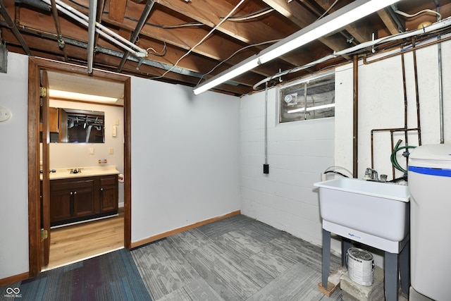 unfinished basement with a sink and baseboards