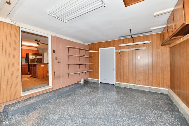 garage featuring stainless steel fridge and wooden walls