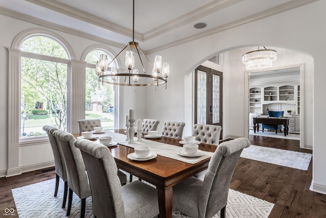 dining room featuring dark wood-style floors, a tray ceiling, arched walkways, and a notable chandelier