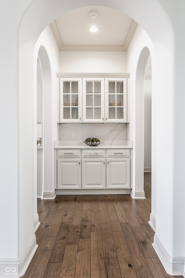 bar with dark wood-style floors, baseboards, and crown molding