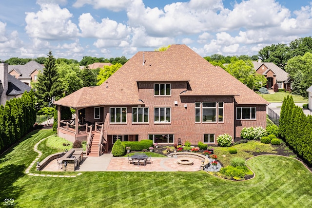 rear view of house featuring brick siding, a fenced backyard, a fire pit, and a patio