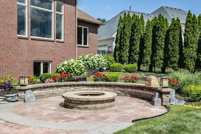 view of patio featuring an outdoor fire pit and fence