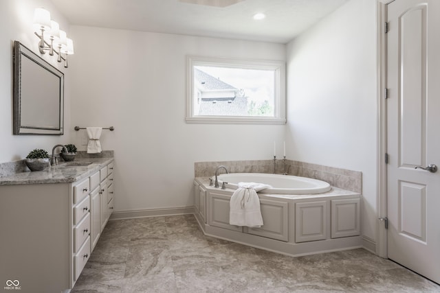 full bath with vanity, a bath, and baseboards