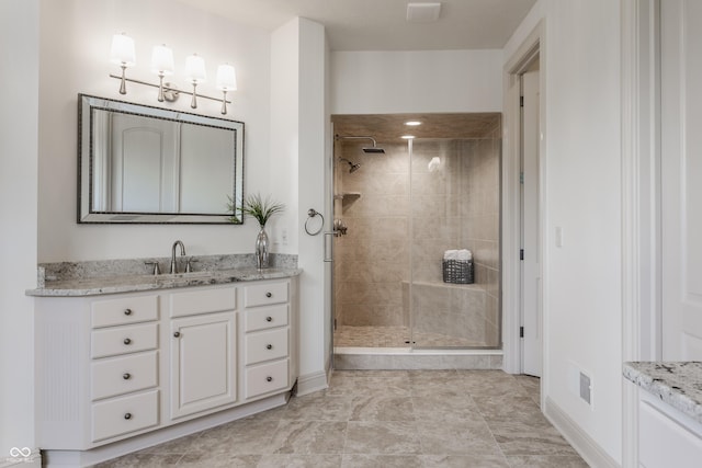 full bathroom featuring a shower stall, vanity, and baseboards