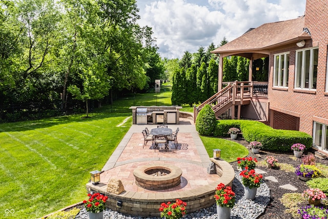 view of yard with stairway, a wooden deck, a fire pit, and a patio