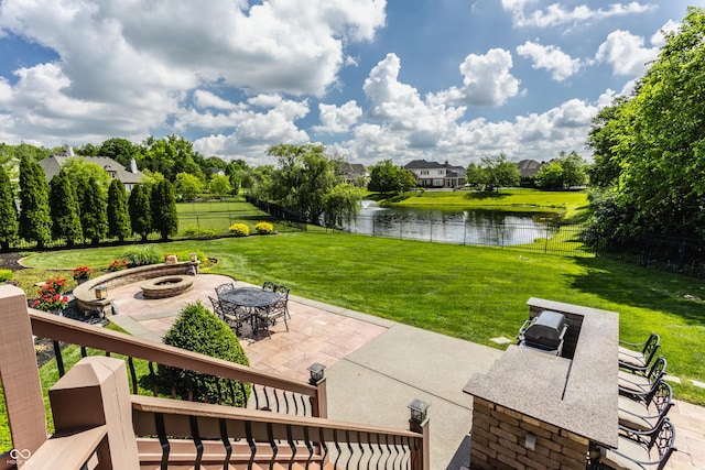 view of patio / terrace with a water view, an outdoor fire pit, and fence