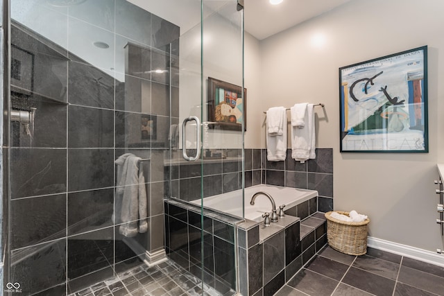 bathroom with a shower stall, a bath, baseboards, and tile patterned floors