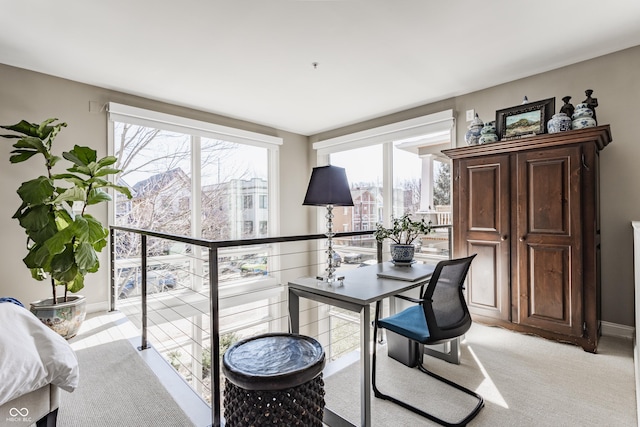 office with baseboards and light carpet