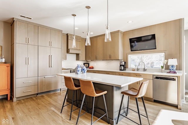 kitchen with dishwasher, a breakfast bar, visible vents, and a sink