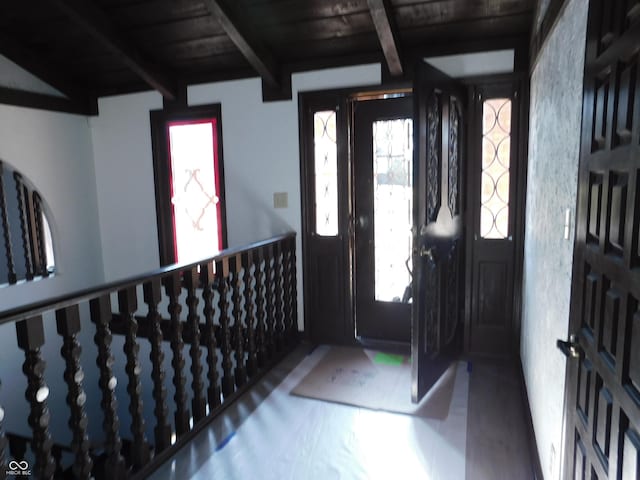 entryway featuring wooden ceiling, a healthy amount of sunlight, and beamed ceiling