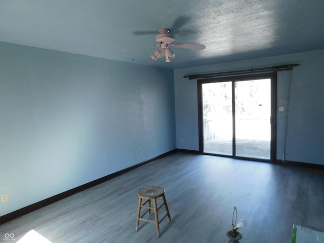 empty room featuring a ceiling fan, a textured ceiling, baseboards, and wood finished floors