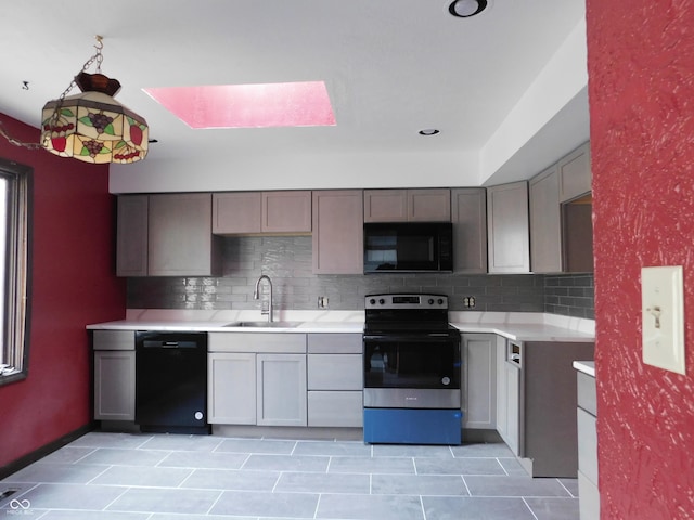 kitchen featuring black appliances, tasteful backsplash, a sink, and light countertops