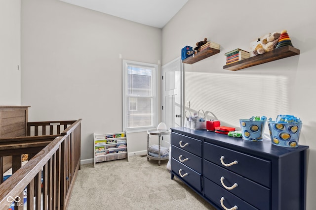 bedroom featuring baseboards, a nursery area, and light colored carpet