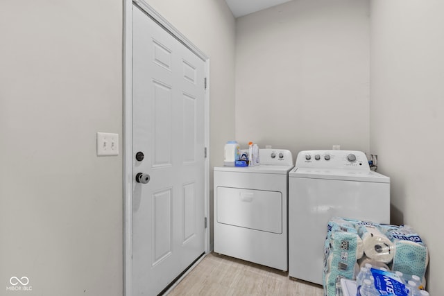 laundry area featuring laundry area, washer and clothes dryer, and light wood finished floors