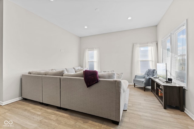 living room with light wood finished floors, recessed lighting, and baseboards