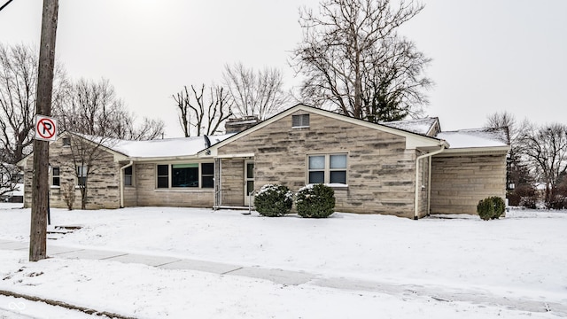 view of front of house featuring stone siding and a chimney