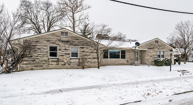 view of front facade featuring stone siding and a chimney