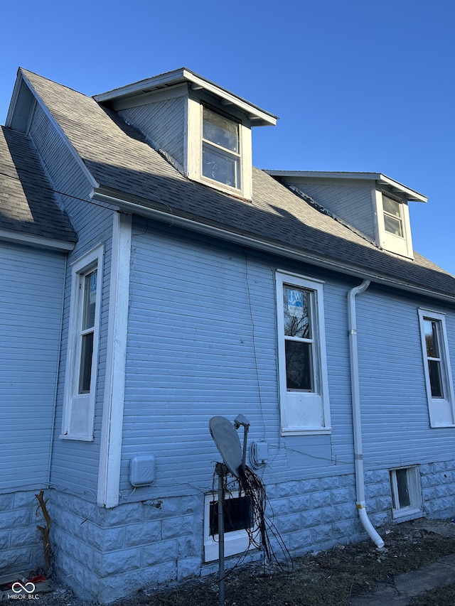 view of side of property with a shingled roof