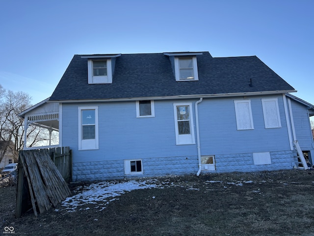 rear view of property with roof with shingles