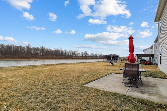 view of yard featuring a water view, a playground, and a patio