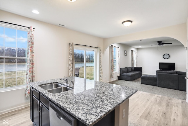 kitchen with arched walkways, visible vents, a sink, and dishwasher