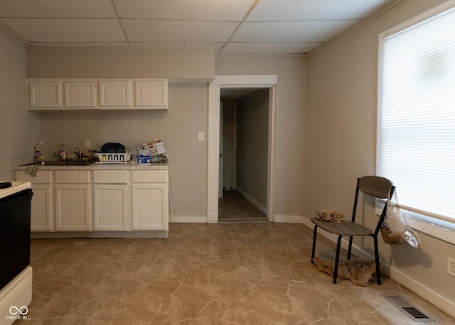 238-240 N Beville Ave, Indianapolis, IN 46201 - kitchen featuring a paneled ceiling, electric range, a sink, white cabinetry, and light countertops