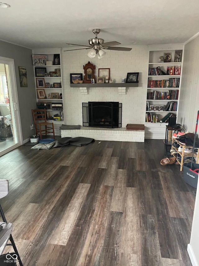 living area featuring ceiling fan, a fireplace, wood finished floors, and built in features