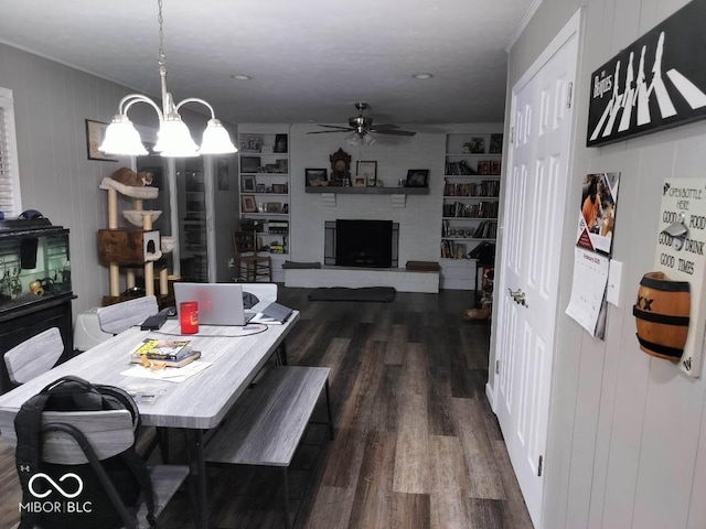 dining area featuring ceiling fan, built in features, a fireplace with raised hearth, and dark wood-type flooring