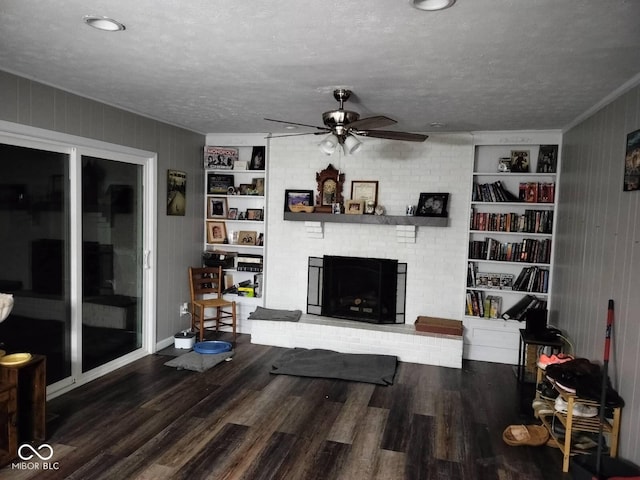 living room with a textured ceiling, built in shelves, and wood finished floors