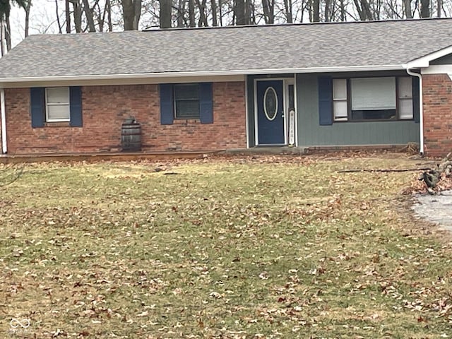 ranch-style house with brick siding, roof with shingles, and a front yard