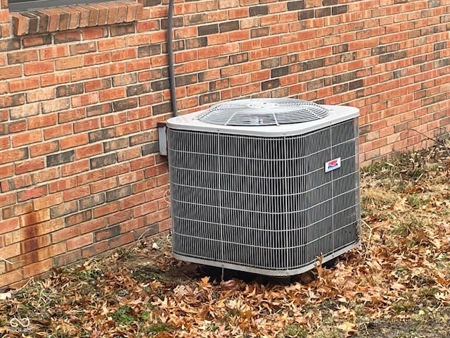 exterior details featuring central AC unit and brick siding