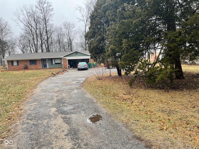 single story home featuring aphalt driveway, a front lawn, and brick siding