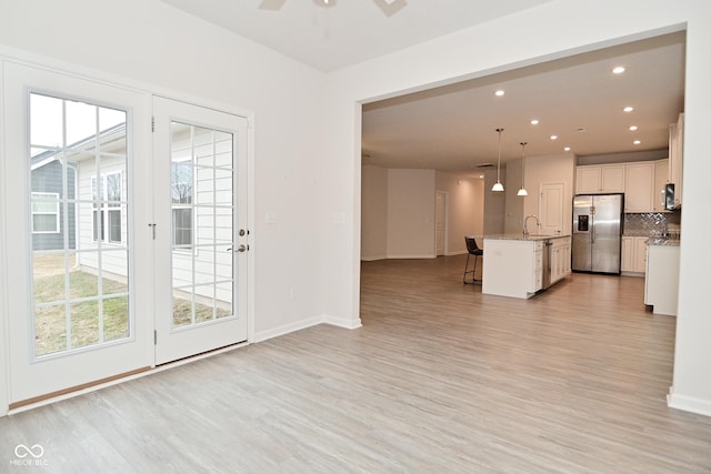 interior space featuring appliances with stainless steel finishes, open floor plan, plenty of natural light, and a breakfast bar area