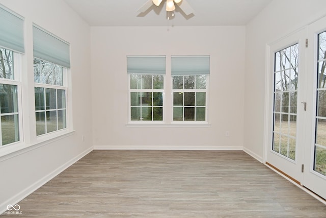 unfurnished sunroom with ceiling fan