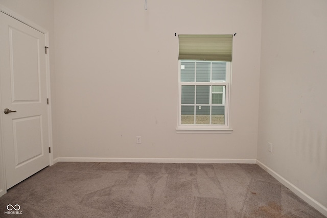 spare room featuring carpet flooring and baseboards