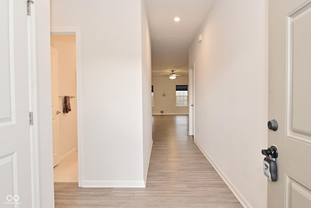 hallway with light wood-style floors, baseboards, and recessed lighting