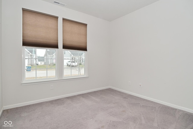 unfurnished room with carpet flooring, visible vents, and baseboards