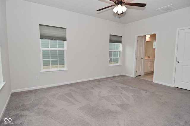 carpeted empty room with visible vents, ceiling fan, and baseboards