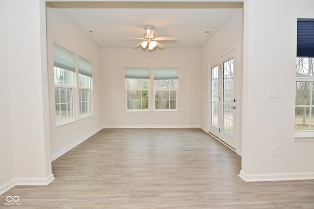 interior space with a healthy amount of sunlight, baseboards, and wood finished floors