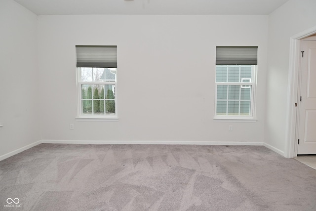 spare room featuring carpet and baseboards