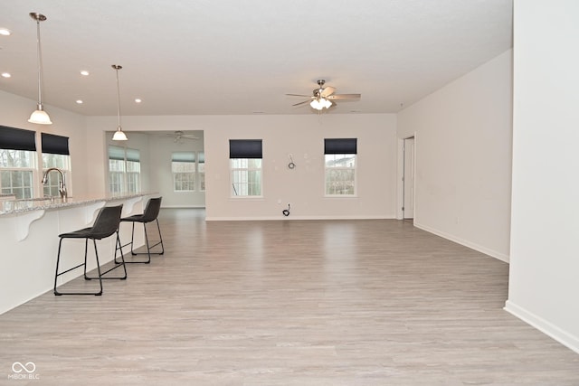 living area featuring recessed lighting, a ceiling fan, and light wood-style floors